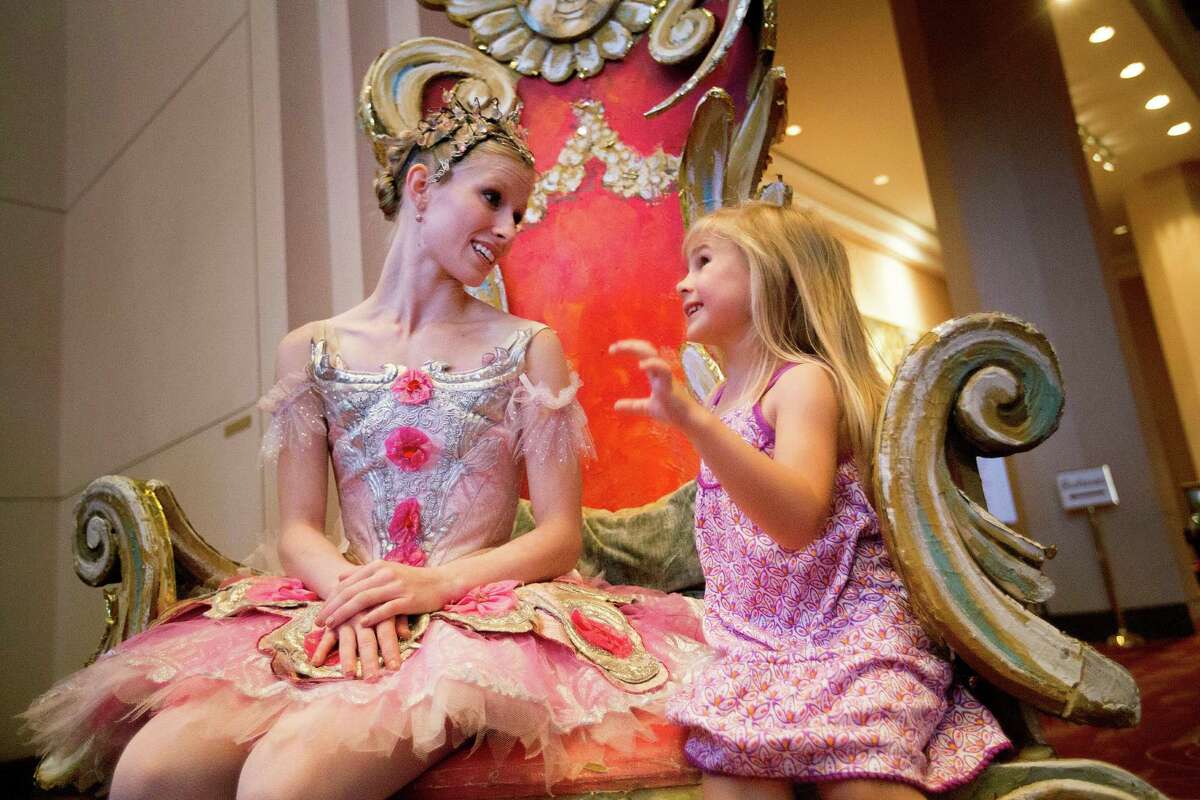 Sophi Lowe, 3, spends time chatting with Houston Ballet's Katelyn May, instead of posing for a picture at the Wortham Theater Center during the 21st Theater District Open House Sunday, Aug. 24, 2014, in Houston. The open house featured, music, dance and theater arts as well as activities for children. The event highlights the performing arts in Houston. ( Johnny Hanson / Houston Chronicle )