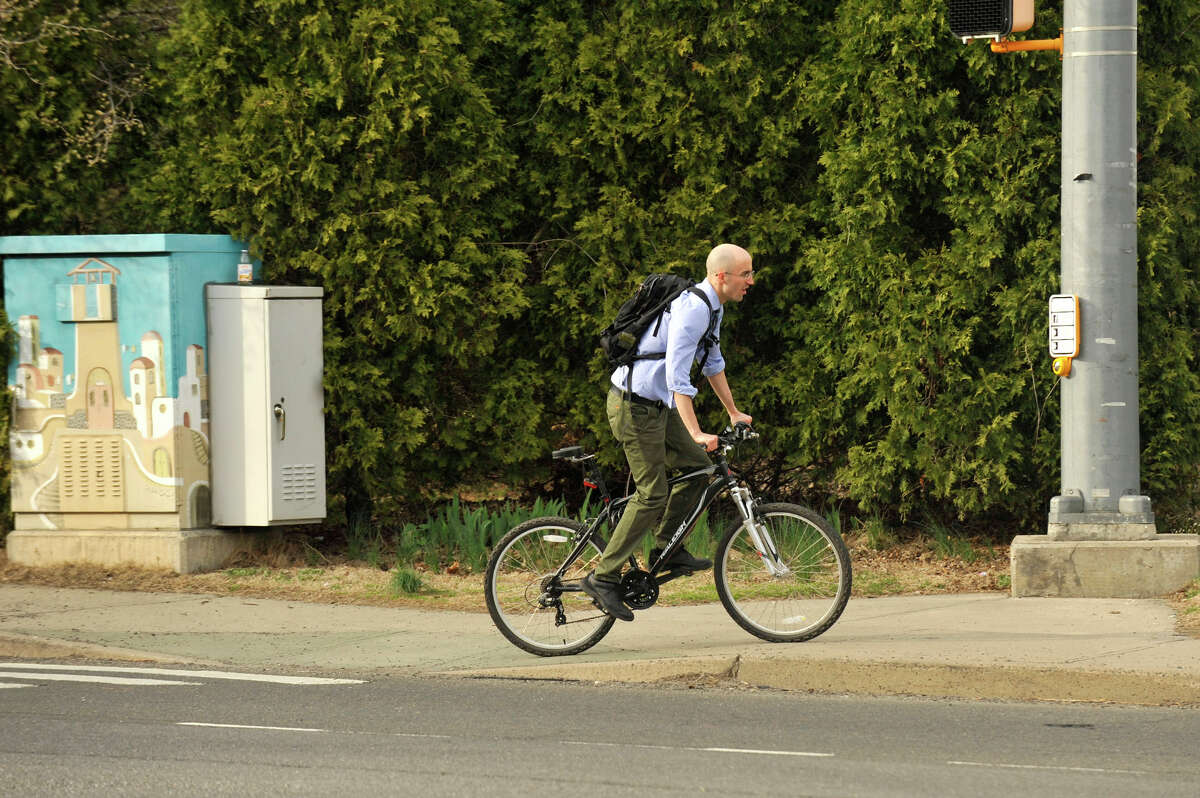 A bicyclist finishes crossing Washington Boulevard in Stamford. The city is considering adding designated bike lanes to increase safety.