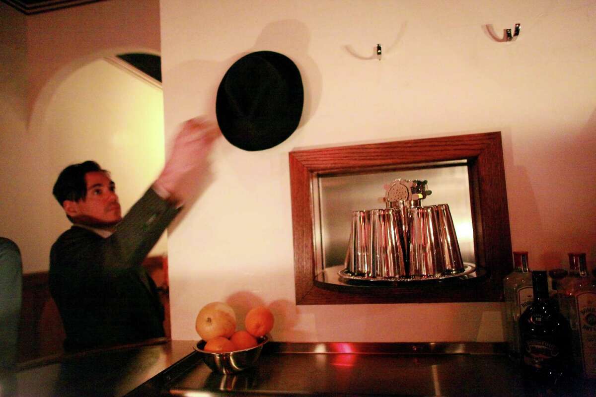 In this file photo, Sasha Petraske, the founder of the cocktail spot Milk & Honey, grabs his hat at the bar in the Manhattan borough of New York, March 30, 2013. Petraske, whose unapologetic dedication to expertly made pre-Prohibition drinks made Milk & Honey a central phenomenon in the modern cocktail revival, died on Aug. 21, 2015, at age 42.