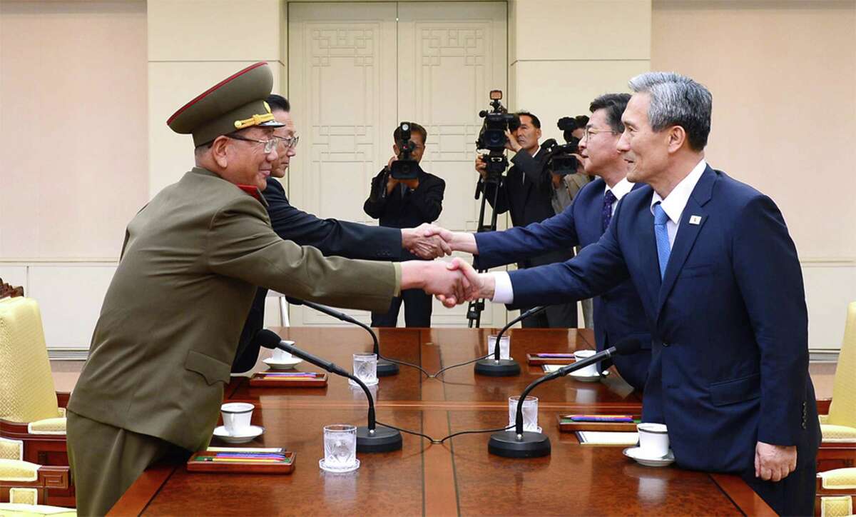 In this photo provided by the South Korean Unification Ministry, South Korean National Security Director, Kim Kwan-jin, right, and Unification Minister Hong Yong-pyo, second from right, shake hands with Hwang Pyong So, left, North Korea' top political officer for the Korean People's Army, and Kim Yang Gon, a senior North Korean official responsible for South Korean affairs, during their meeting at the border village of Panmunjom in Paju, South Korea, Saturday, Aug. 22, 2015. South Korea and North Korea agreed Saturday to hold their first high-level talks in nearly a year at a border village to defuse mounting tensions that have pushed the rivals to the brink of a possible military confrontation. (The South Korean Unification Ministry via AP)