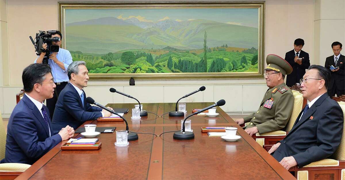 In this photo provided by the South Korean Unification Ministry, South Korean Unification Minister Hong Yong-pyo, left, and National Security Director, Kim Kwan-jin, second from left, meet with Kim Yang Gon, right, a senior North Korean official responsible for South Korean affairs, and Hwang Pyong So, North Korea' top political officer for the Korean People's Army, at the border village of Panmunjom in Paju, South Korea, Saturday, Aug. 22, 2015. (The South Korean Unification Ministry via AP)