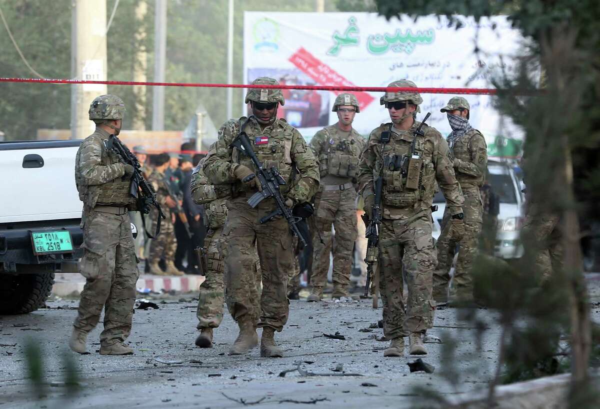 U.S. soldiers inspect the site of a suicide attack in the heart of Kabul, Afghanistan, Saturday, Aug. 22, 2015. The suicide car bomber attacked a NATO convoy traveling through a crowded neighborhood in Afghanistan's capital Saturday, killing at least 10 people, including three NATO contractors, authorities said. (AP Photo/Massoud Hossaini)