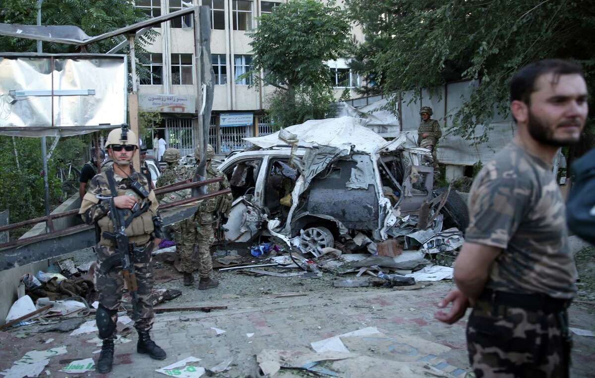 Afghan security forces and British soldiers inspect the site of a suicide attack in the heart of Kabul, Afghanistan. The bomber attacked a NATO convoy in a crowded capital neighborhood. ﻿