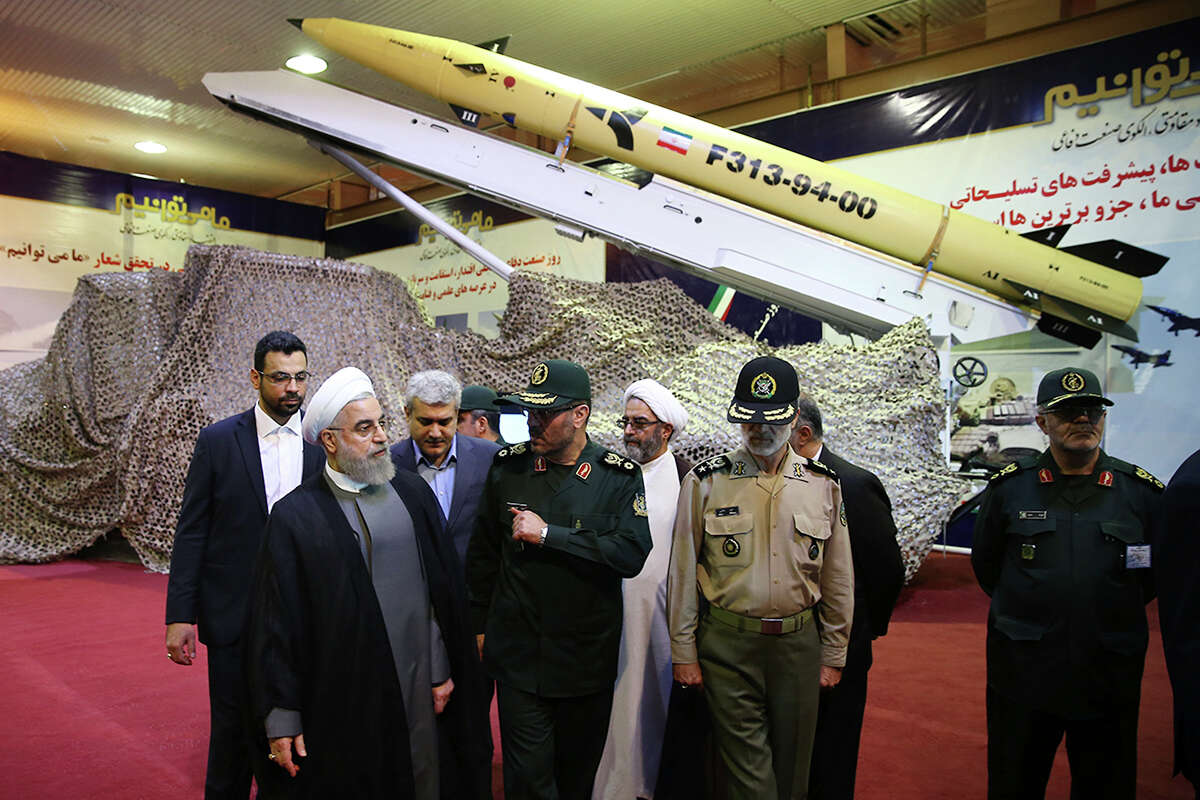 In this photo released by the official website of the office of the Iranian Presidency on Saturday, Aug. 22, 2015, Iran's President Hassan Rouhani, left, listens to Defense Minister Hossein Dehghan after unveiling the surface-to-surface Fateh-313, or Conqueror, missile in a ceremony marking Defense Industry Day, Iran. Iran unveiled a short-range solid fuel ballistic missile Saturday, an upgraded version that the government says can more accurately pinpoint targets. (Iranian Presidency Office via AP)