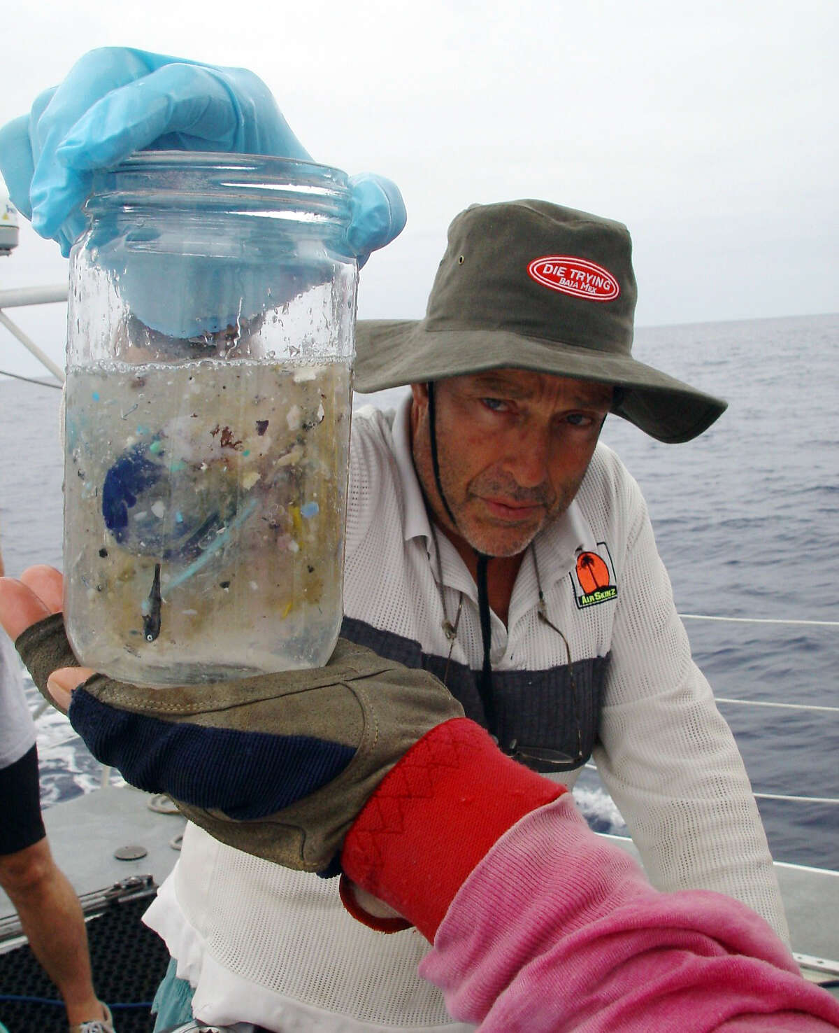 This handout picture shows marine researcher Charles Moore on an expedition in the Pacific Ocean sometime between July through September of 2002. He holds a sample of ocean water from the North Central Pacific Gyre that contains small pieces of plastic. Moore, who works at the Long Beach-based Algalita Marina Research Foundation, has been studying the stew of plastic and marine debris floating in the ocean. Moore has since discovered a second similar garbage patch in the South Pacific.