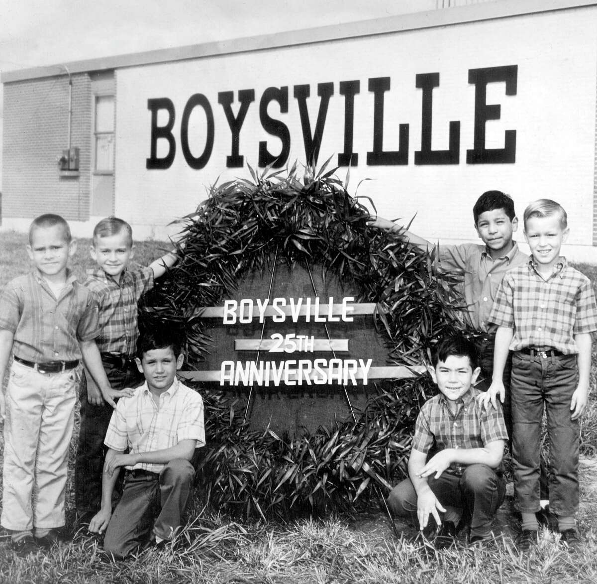 Six young boys are positioned around a sign proclaiming the 25th anniversary of Boysville in a June 12, 1968, photo.