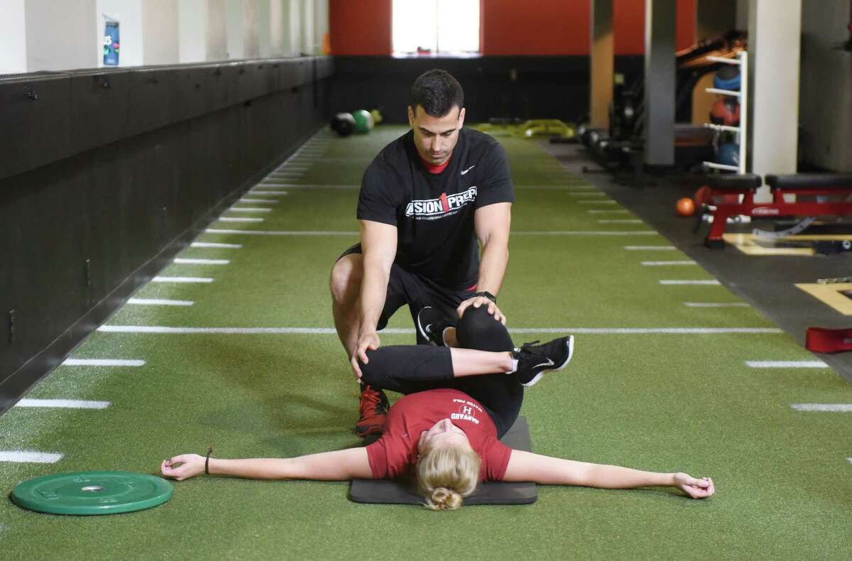 Founder and Strength Coach Todd Vitale stretches Hollis Jomo, a rising sophomore on the Harvard water polo team, after a workout at Division 1 Prep in the Glenville section Greenwich, Conn. Tuesday, Aug. 25, 2015. Division 1 Prep is a strength and conditioning center that provides personalized, sport-specific training programs for aspiring Division 1 athletes, as well as adults who want to achieve optimal fitness.