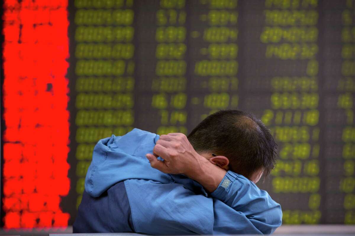 A Chinese investor monitors stock prices Tuesday at a brokerage house in Beijing. Despite lower unemployment rates, rising home prices and low inflation in America, the economic slowdown in China has wreaked havoc on stock, commodity and foreign exchange markets in America.