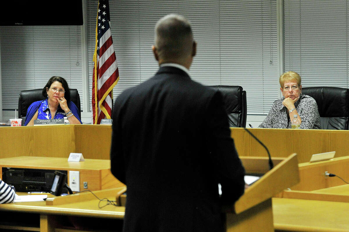 Assistant Principal of Rippowam Middle School Michael Rinaldi speaks against separation agreements as board Vice President Lorraine Olson, left, and board President Jackie Heftman, right, listen during the Board of Education meeting at the Stamford Government Center in Stamford, Conn., on Tuesday, Aug. 25, 2015.