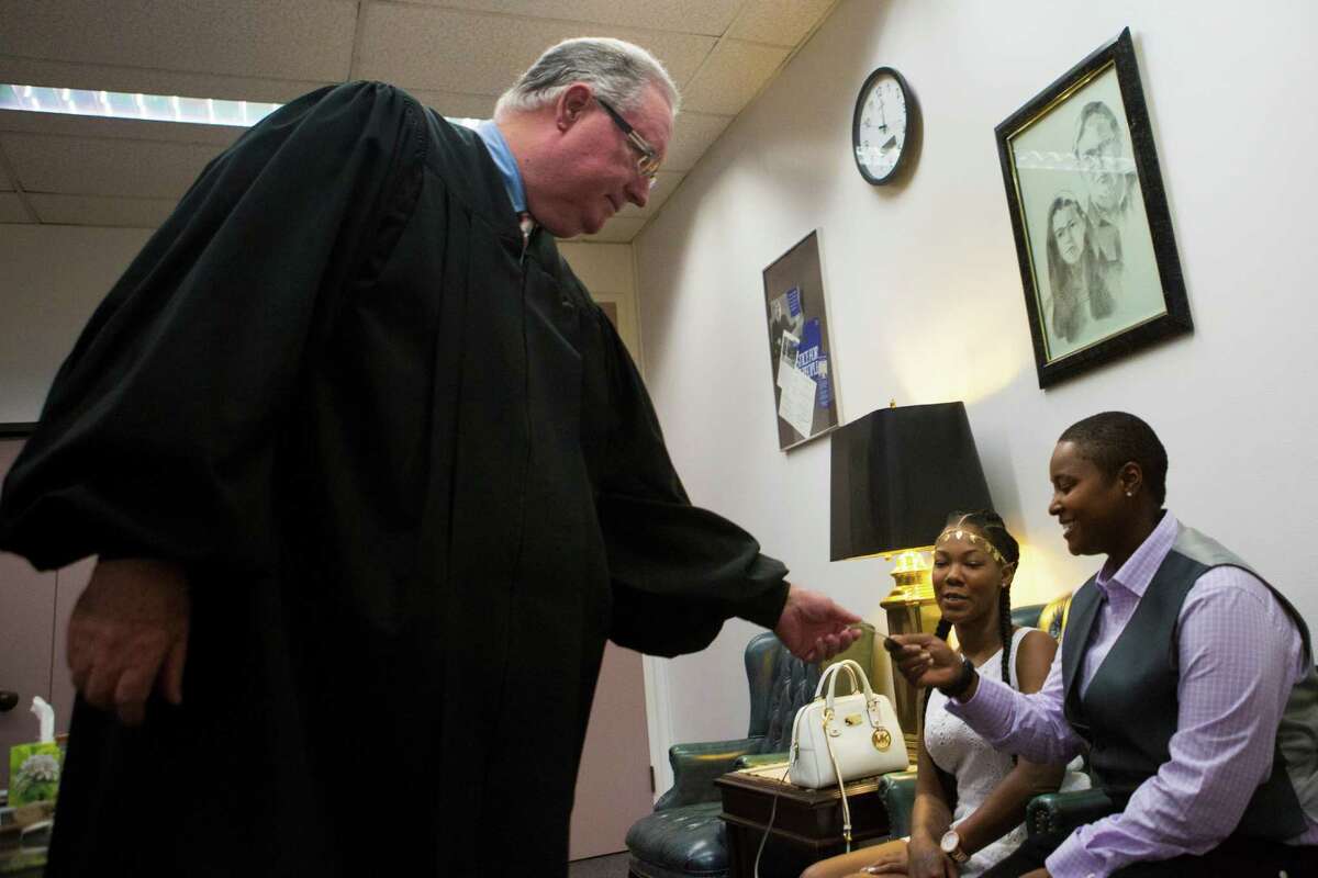 Judge Dale Gorczynski gives Hattie Givens his business card with his name and number so she can pass it on to other same-sex couples looking to get married and not finding a judge that would perform the ceremony. Friday, Aug. 21, 2015, in Houston.