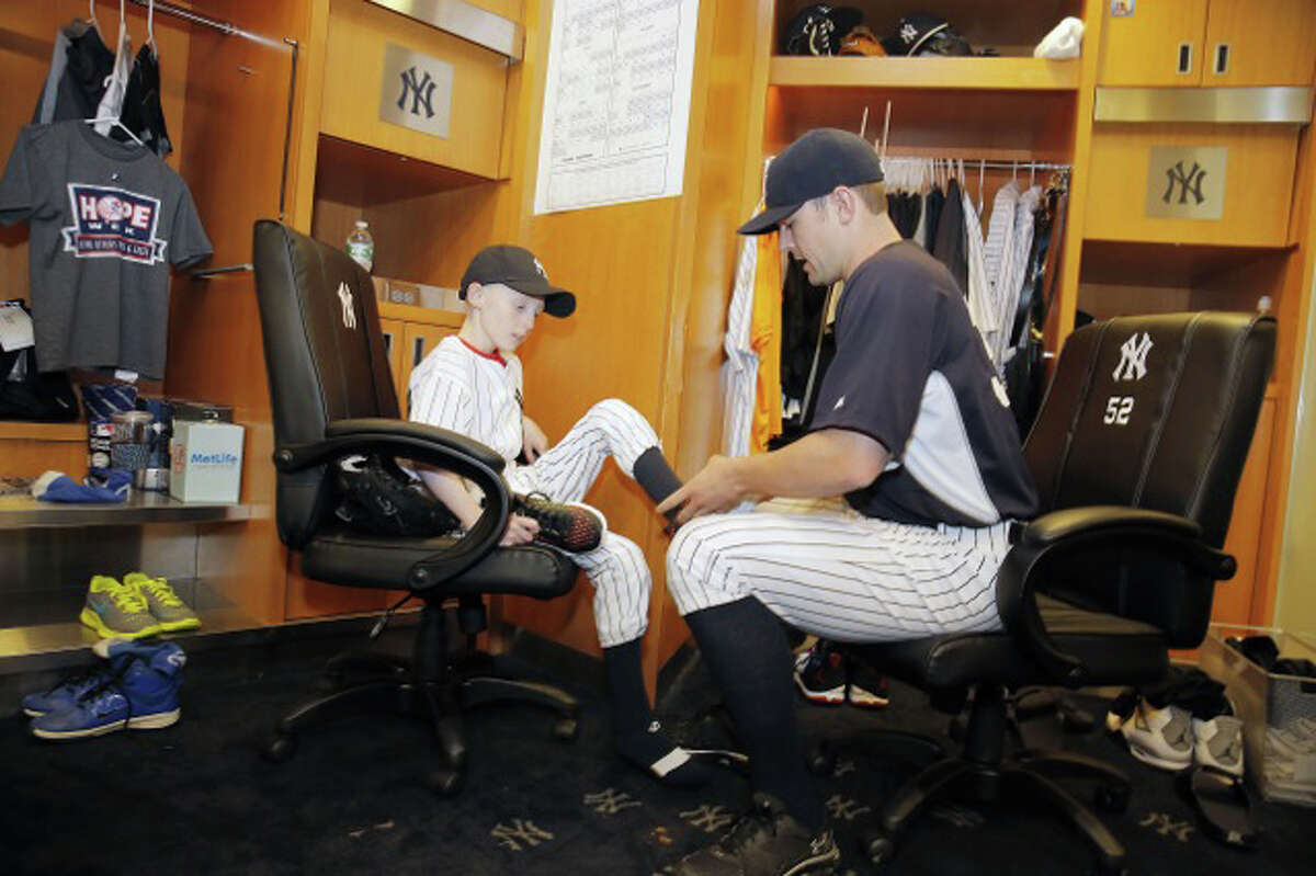 Yankees closer David Robertson helps HOPE Week honoree Sean Callahan to get ready for Wednesday night's game.