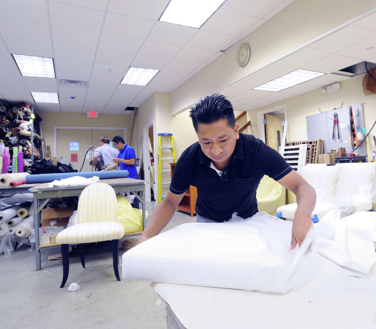 Juan Guaman, an upholsterer for Tiger Lily's Interior Design Studio in Greenwich, works Wednesday on the white seat cushion that Pope Francis will use during his Madison Square Garden appearance in New York City in September.