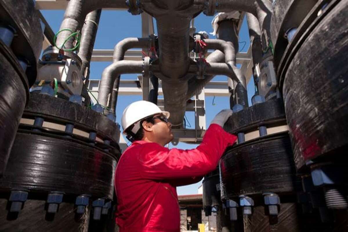 In an undated photo from a 2015 investor presentation, a Cameron International worker examines oil field separation and processing equipment produced by the Houston-based manufacturer. Schlumberger said on Aug. 26, 2015, that it would acquire Cameron in a $12.8 billion deal. (Cameron International photo)