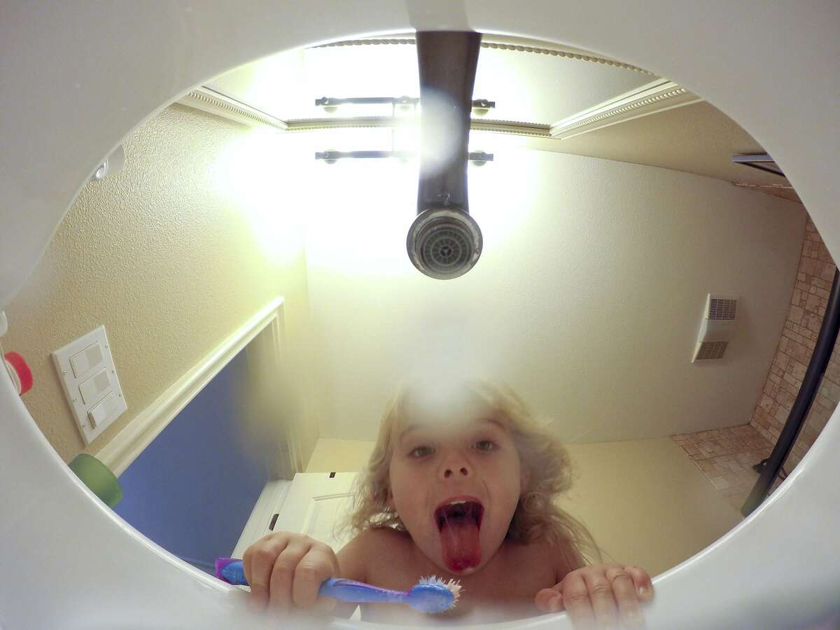 Gillian Flaccus' daughter leaned to brush her teeth without leaving the water running at the family's home, Thursday, Aug. 20, 2015 near Los Angeles. Flaccus, an Associated Press reporter, and her husband are using the California drought to teach their children life lessons about conservation. (AP Photo/Chris Carlson)