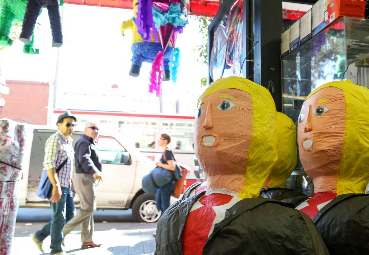 People walking past Discount City Store on Mission Street can't help but look at the large Donald Trump pinatas displayed there on Thursday, August 27. 2015 in San Francisco, Calif.