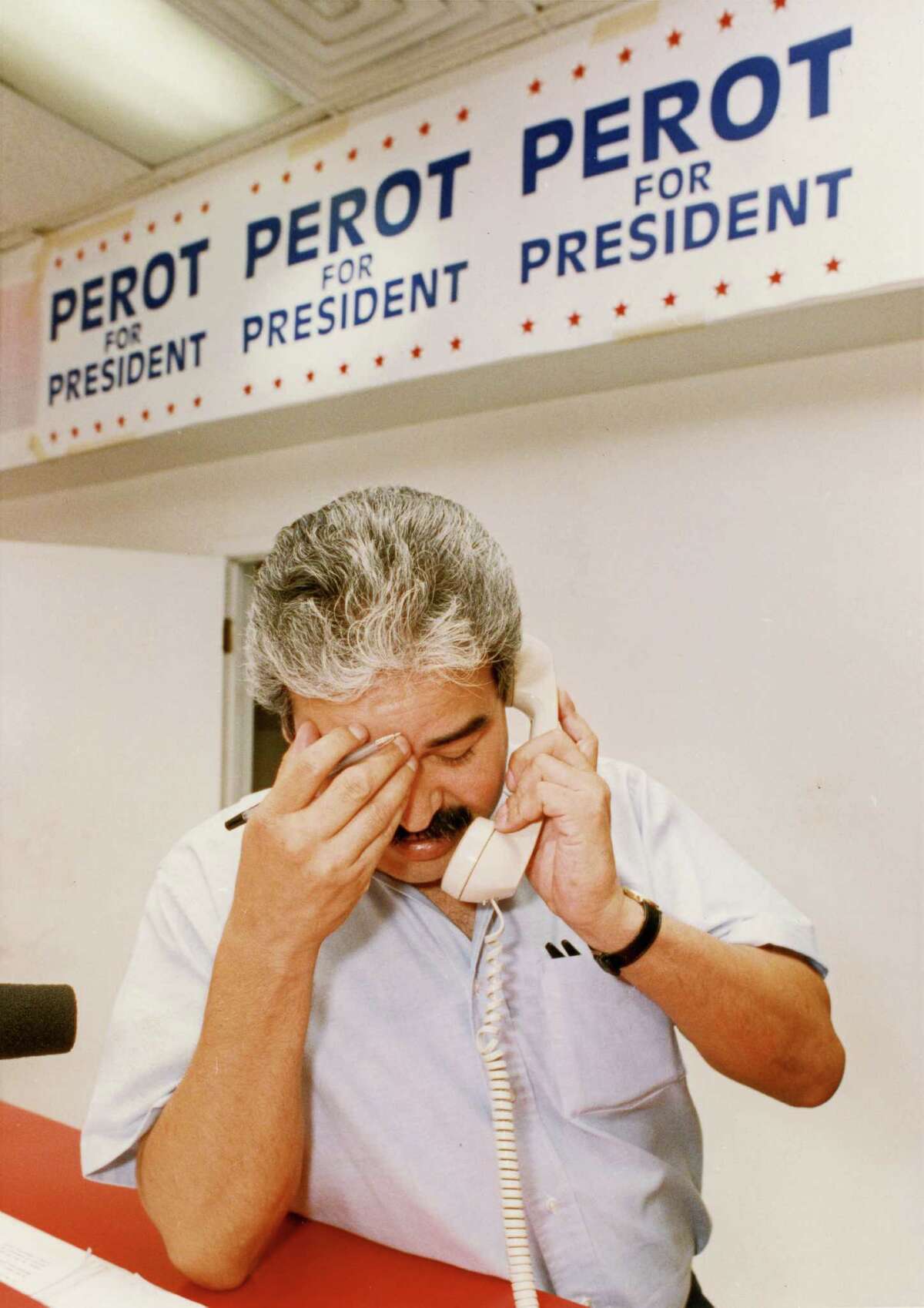 07/16/1992 - Joe Martinez, office manager for the "Perot for President" Houston downtown headquarters, 910 Main, handles a phonecall moments after H. Ross Perot announced he was cutting short his drive for the White House. Perot volunteers at the Houston-area offices spent most of the day answering phones trying to calm angry callers.