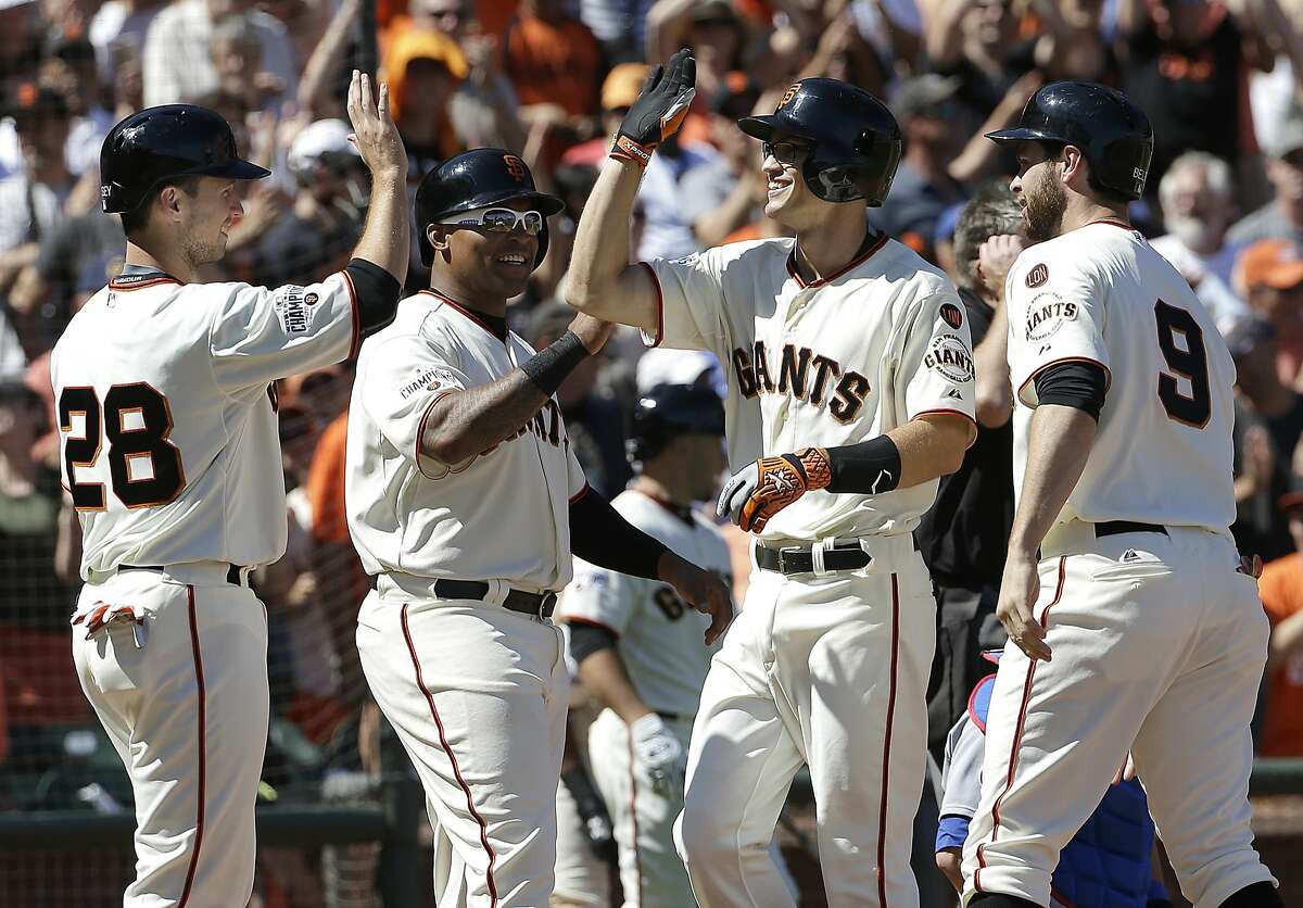 San Francisco Giants' Kelby Tomlinson, second from right, is congratulated after hitting a grand slam that scored Buster Posey, Marlon Byrd and Brandon Belt, from left, against the Chicago Cubs during the eighth inning of a baseball game in San Francisco, Thursday, Aug. 27, 2015. The Giants won 9-1. (AP Photo/Jeff Chiu)