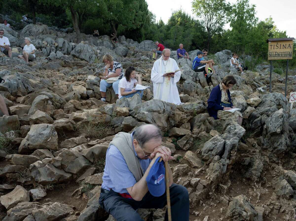 Pilgrims gather on the hill above the Bosnian town of Medjugorje, where in 1981 six children said the Virgin Mary appeared to them. The site has drawn millions of faithful and skeptics.﻿