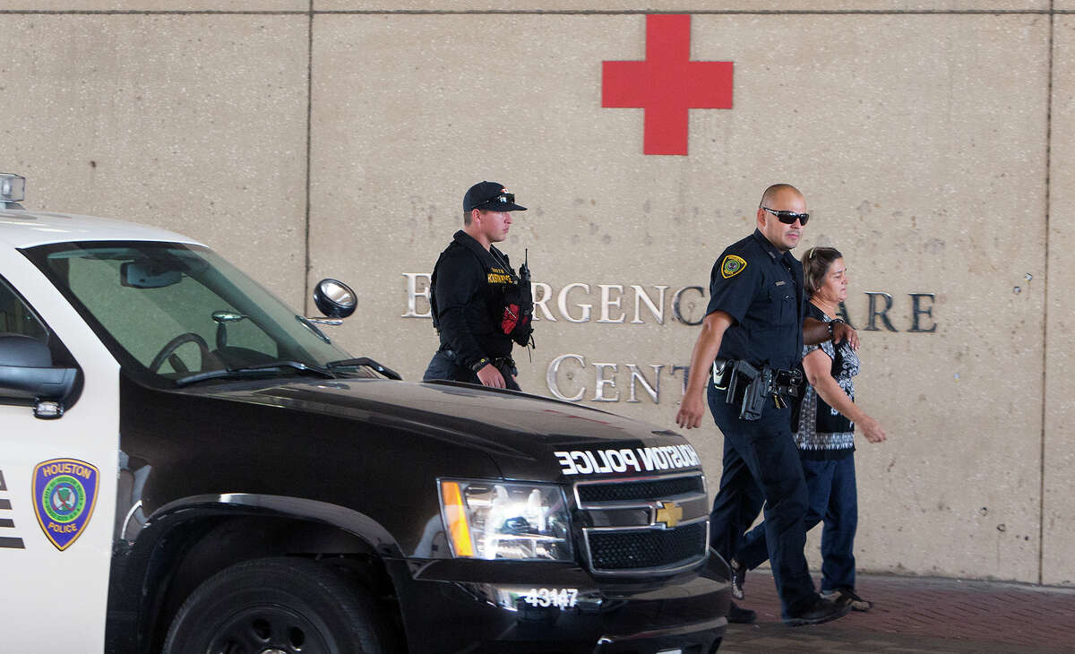 A woman is escorted at St. Joseph's Medical Center on Thursday after an off-duty officer wounded a combative patient.﻿
