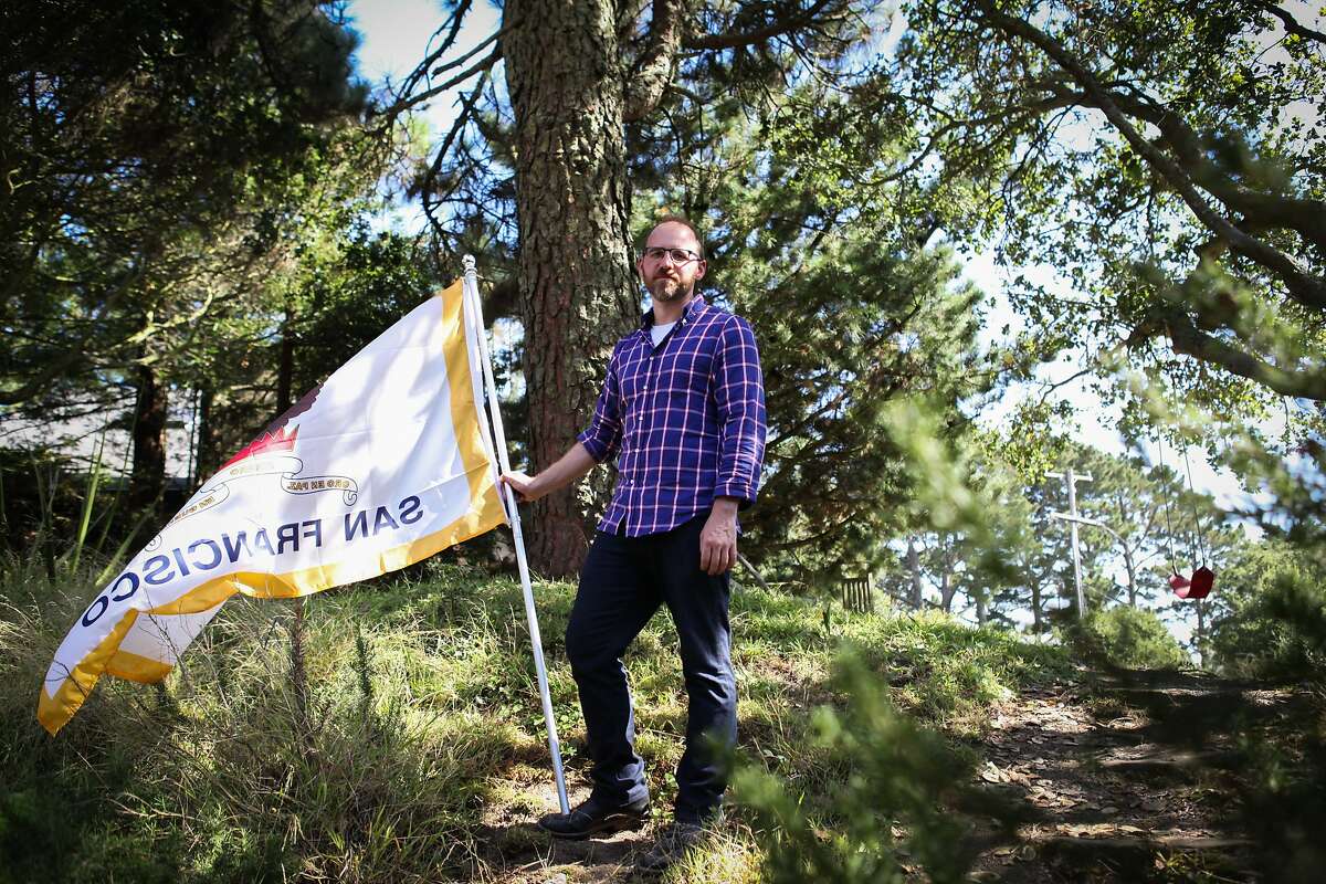 Roman Mars, host and creator of design radio show 99% Invisible, stands outside his home with the San Francisco flag in Kensington, California on August 27, 2015. Mars has a campaign to change San Francisco's flag as he feels it's no longer representative of the city. He also believes that flags should not have writing on them since they are two sided and thus often read backwards.