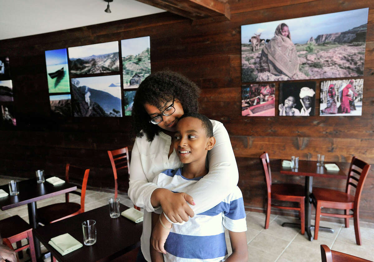 Elsa Mekonen embraces her cousin, Afewerki Tesfagabr, in the dining area of Teff, an Ethiopian and Eritrean restaurant, in Stamford, Conn., on Wednesday, Aug. 19, 2015. The restaurant is one of only a few African-American-owned restaurants in Stamford. Teff recently opened its doors on July 30.