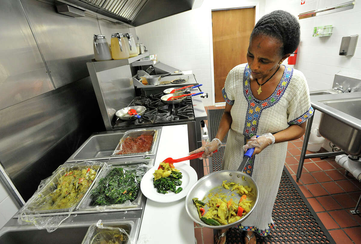 Hadas Mengesha adds atkilt gomen, a vegetable medly, to a dish at Teff, an Ethiopian and Eritrean restaurant, in Stamford, Conn., on Wednesday, Aug. 19, 2015. The restaurant is one of only a few African-American-owned restaurants in Stamford. Teff recently opened its doors on July 30.