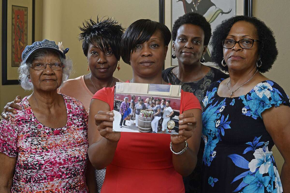 Five members of the Sistahs on the Reading Edge book club, all of Antioch, from left, Katherine Neal, Georgia Lewis, Lisa Renee Johnson, Allisa Carr and Sandra Jamerson stand together at Johnson's home in Antioch, Calif., on Monday, Aug. 24, 2015. The five women were among 11 African-American women who were were booted off the Napa Valley Wine Train two days before. Johnson holds a photograph of the group that was taken before boarding the train. A race discrimination suit was to be filed on Thursday, Oct. 1, 2015.
