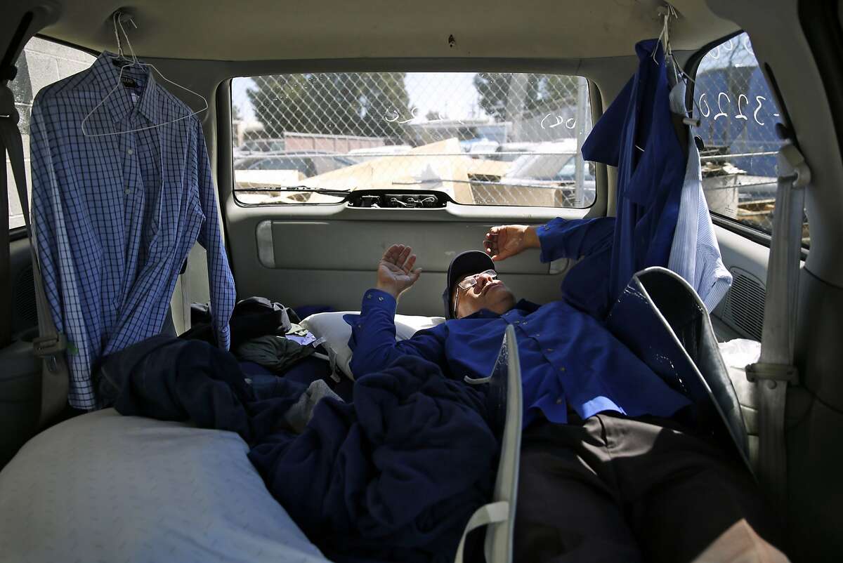 Apple bus driver Scott Peebles naps in his van between shifts in San Jose , Calif., on Thursday, Aug. 27, 2015.