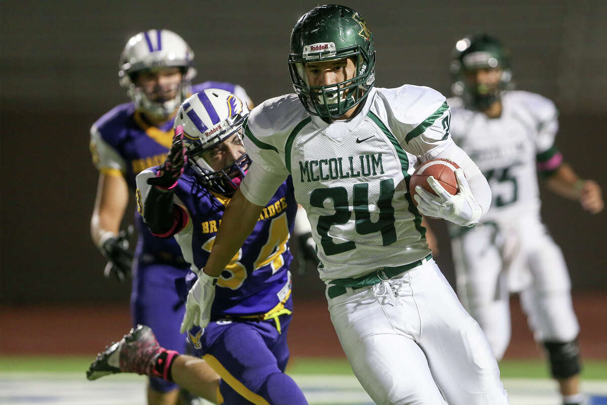 McCollum’s Mike Ramirez (24) looks for running room as Brackenridge’s Eddie Rodriguez tries to bring him down from behind during the first half of their game at Alamo Stadium onOct. 16, 2014. Brackenridge beat the Cowboys 44-28.