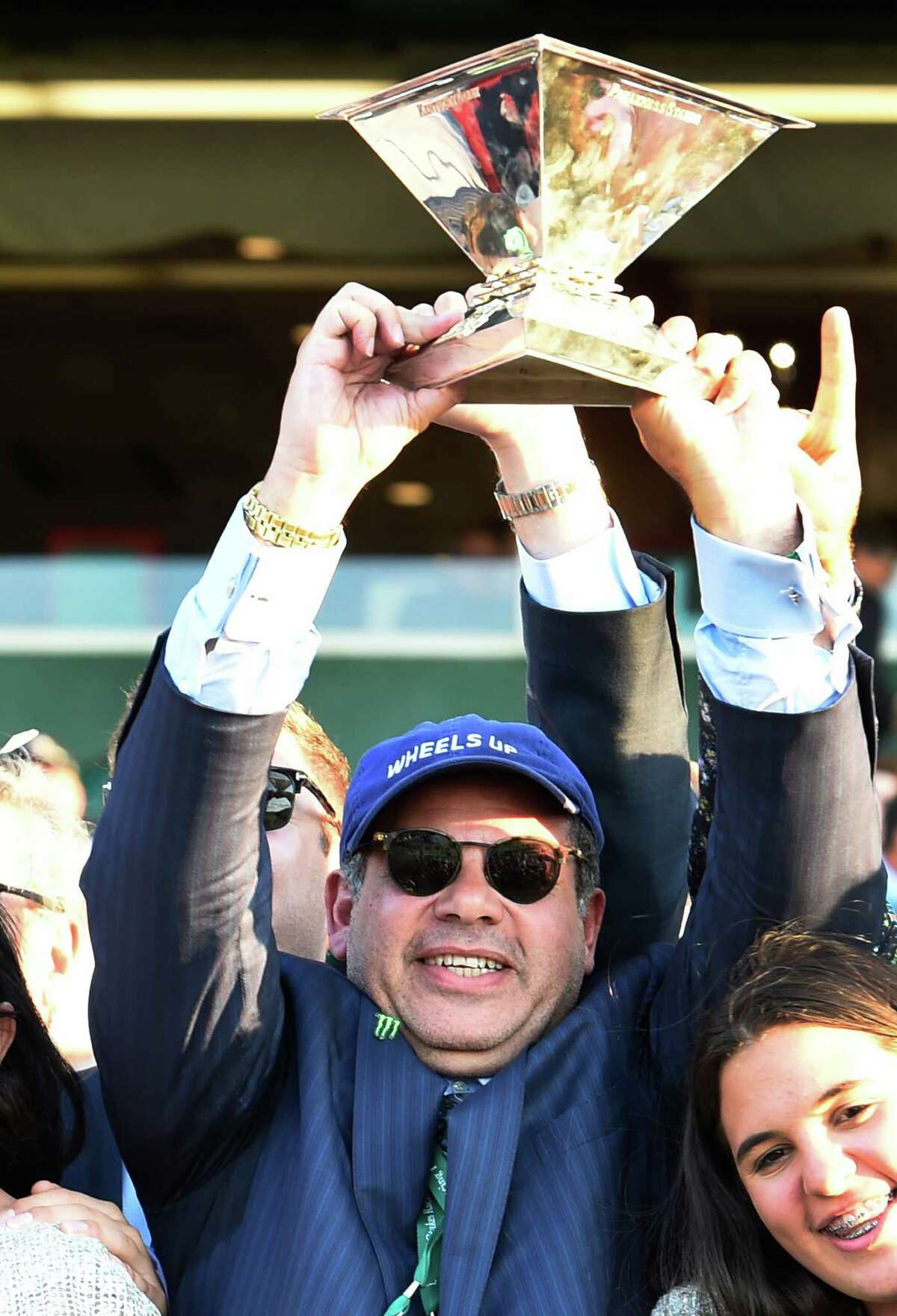 American Pharoah's owner Ahmed Zayat holds the Triple Crown trophy aloft after his horse made his way to the record books by winning the 147th running of the Belmont Stakes and thoroughbred racing's Triple Crown June 6, 2015 at Belmont Park in Elmont, N.Y. (Skip Dickstein/Times Union)
