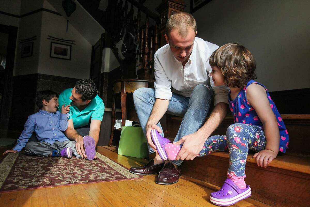 David Jacoby (second from left) helps son Max Jacoby put on his shoes and Brett Davis (center), and Airbnb guest helps Olivia Jacoby put on her shoes before school, in the Jacoby's home in San Francisco, California, on Friday, Aug. 28, 2015. Brett Davis, is a guest, who's staying in the Jacoby's Airbnb. Proposition F, the ballot initiative to rein in short-term rentals, would make it easier for neighbors to sue other neighbors, like the Jacoby's for hosting Airbnb guests.