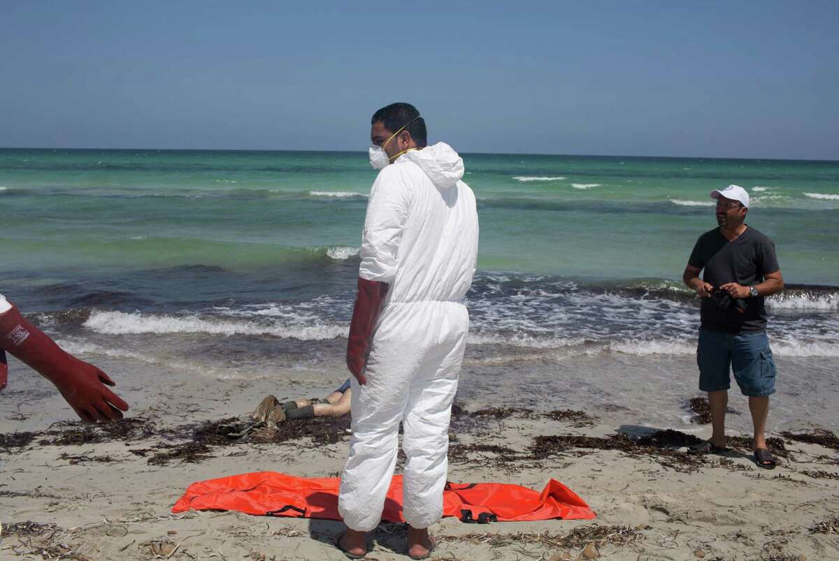 Workers for the Red Crescent pull dead migrants from the water and place them in orange-and-black body bags laid out on the waterfront in Zuwara, about 105 kilometers (65 miles) west of Tripoli, Libya, Friday, Aug. 28, 2015. Two ships went down Thursday off the western Libyan city, where Hussein Asheini of the Red Crescent said over 100 bodies had been recovered. About 100 people were rescued, according to the Office of the U.N. High Commissioner for Refugees, with at least 100 more believed to be missing. (AP Photo/Mohamed Ben Khalifa)