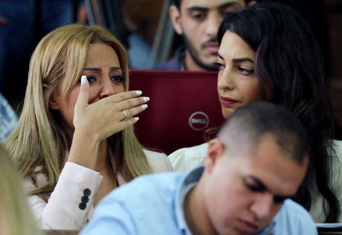 Marwa Fahmy wife of Canadian Al-Jazeera English journalist Mohammed Fahmy, bursts into tears, as she is watched by human rights lawyer Amal Clooney, after the verdict in a courtroom in Tora prison in Cairo, Egypt, Saturday, Aug. 29, 2015. An Egyptian court on Saturday sentenced three Al-Jazeera English journalists to three years in prison, the last twist in a long-running trial criticized worldwide by press freedom advocates and human rights activists. (AP Photo/Amr Nabil)