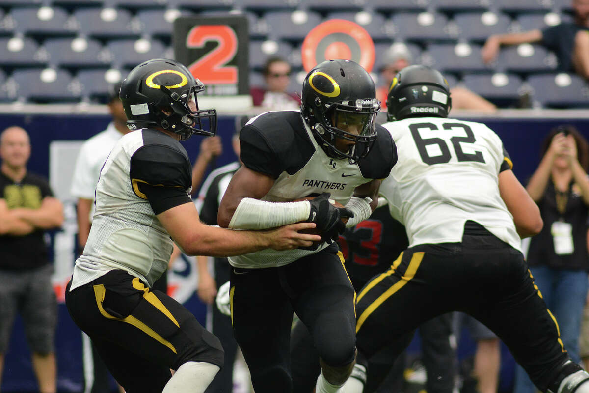 Klein Oak senior running back J.T. Smith, center, takes a handoff from junior quarterback Brandon Blair in the 4th quarter of their matchup with Langham Creek as part of a high school football doubleheader at NRG Stadium in Houston on Saturday, August 29, 2015. (Photo by Jerry Baker/Freelance)
