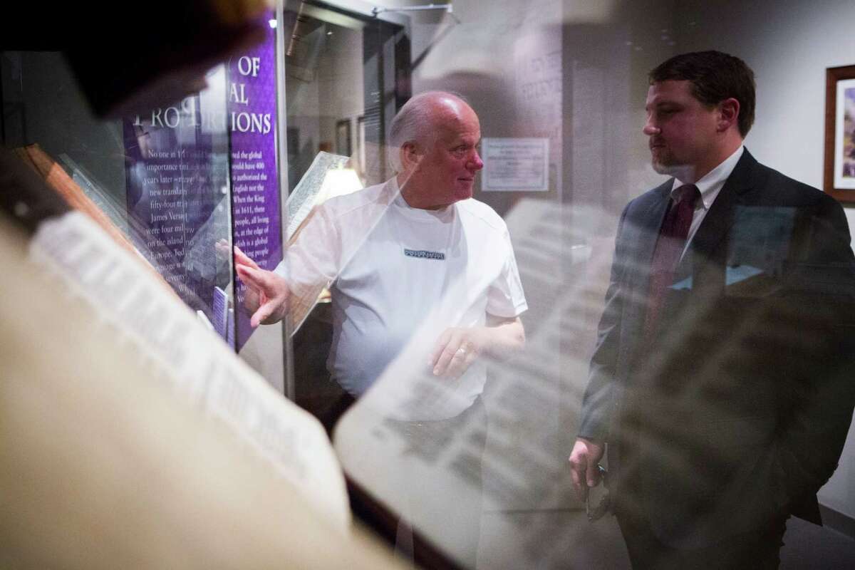 Rick Ogden, left, points out an exhibition to Kyle Vardeman﻿﻿ at the Dunham Bible Museum. The Bibles displayed, translated by order of King James I, are among almost 6,000 writings shown there.