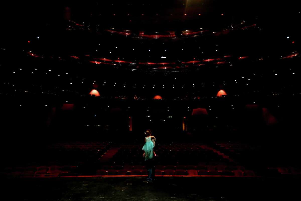 A father and daughter move on stage in the Brown Theater at the Wortham Theater Center during the 22nd Annual TransCanada Theater District Open House Sunday, Aug. 30, 2015, in Houston.