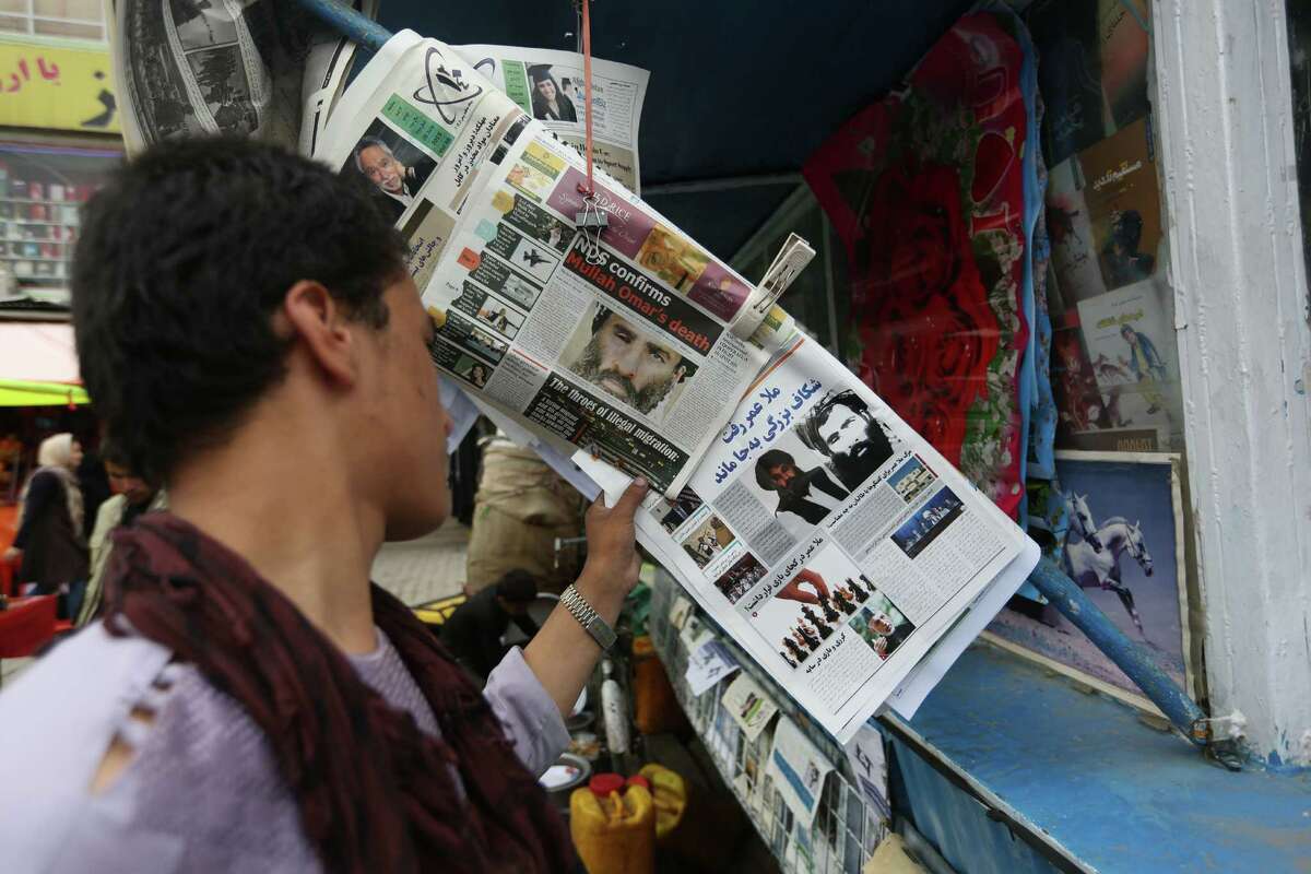 FILE - In this Aug. 1, 2015 file photo, an Afghan reads local newspapers carrying headlines about the new leader of the Afghan Taliban, Mullah Akhtar Mansoor, and former leader Mullah Mohammad Omar who was declared dead, on display at a newsstand in Kabul, Afghanistan. Defying the fury of Afghanistan?’s government and warnings from Washington, Pakistani authorities appear to be turning a blind eye to a meeting of hundreds of Taliban followers in Quetta, Pakistan, near the Afghan border, aimed at resolving a dispute over the group?’s leadership following the announcement of the death of one-eyed figurehead Mullah Mohammad Omar. (AP Photo/Rahmat Gul, File) ORG XMIT: CAITH102