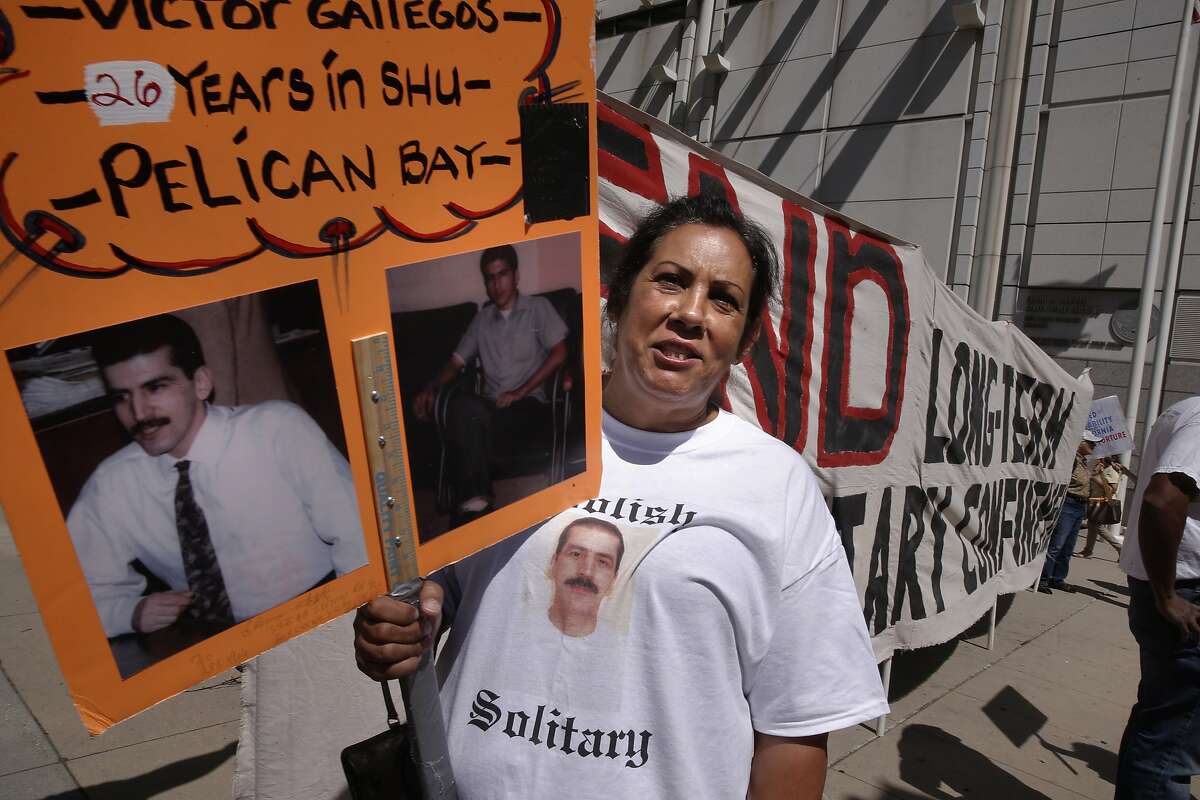 Angie Gallegos, of Santa Monica, holds a sign showing her brother Victor who has been in solitary confinement at Pelican Bay for the past 26 years, she joins others in front of the Elihu Harris State of California Building in downtown Oakland, Calif., on Tues. September 1, 2015, after the State of California California agreed to move thousands of prison inmates out of solitary confinement.