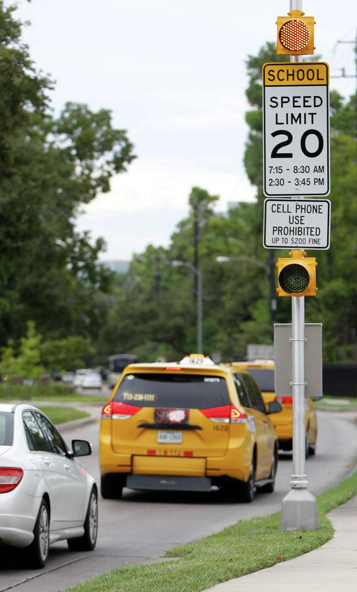 Traffic passes a "cell phone prohibited" sign on Gessner in front of Frostwood Elementary School on Tuesday, Sept. 1, 2015. A 2009 state law prohibits texting and hand-held cell phone use in school zones, but cities must post signs to enforce the ban.