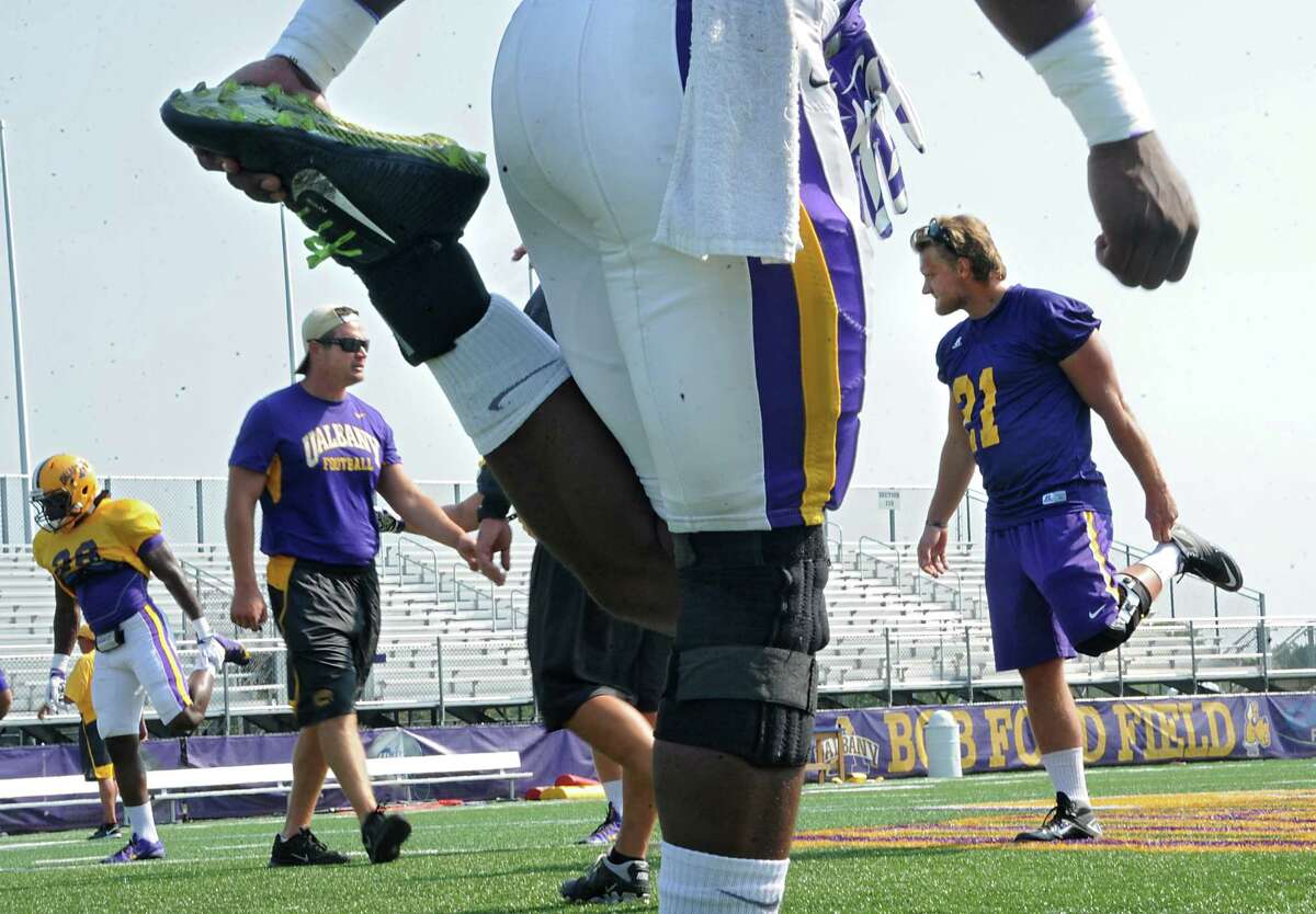 UAlbany football player Nic Ketter, right, who is injured this season, is seen stretching with the team during practice in Albany N.Y. (Lori Van Buren / Times Union)