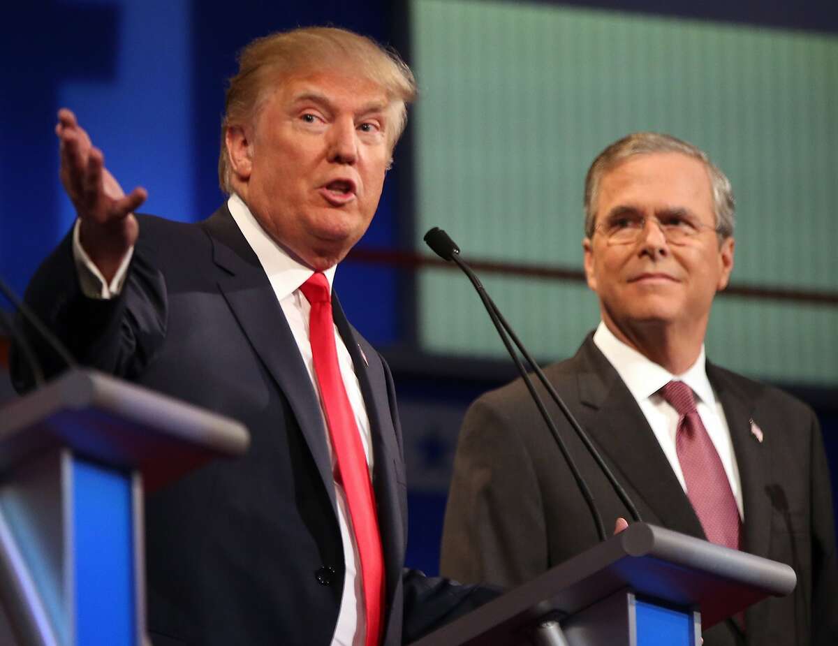 FILE - In this Aug. 6, 2015, file photo, Republican presidential candidates Donald Trump and Jeb Bush participate in the first Republican presidential debate at the Quicken Loans Arena in Cleveland. Trump is going after Bush with a new campaign video about immigration. In the video, Bush is shown saying in a 2014 interview that illegal immigration is "not a felony" but rather an "act of love." The video has images of three men who were in the country illegally and have been charged or convicted in killings. (AP Photo/Andrew Harnik, File)