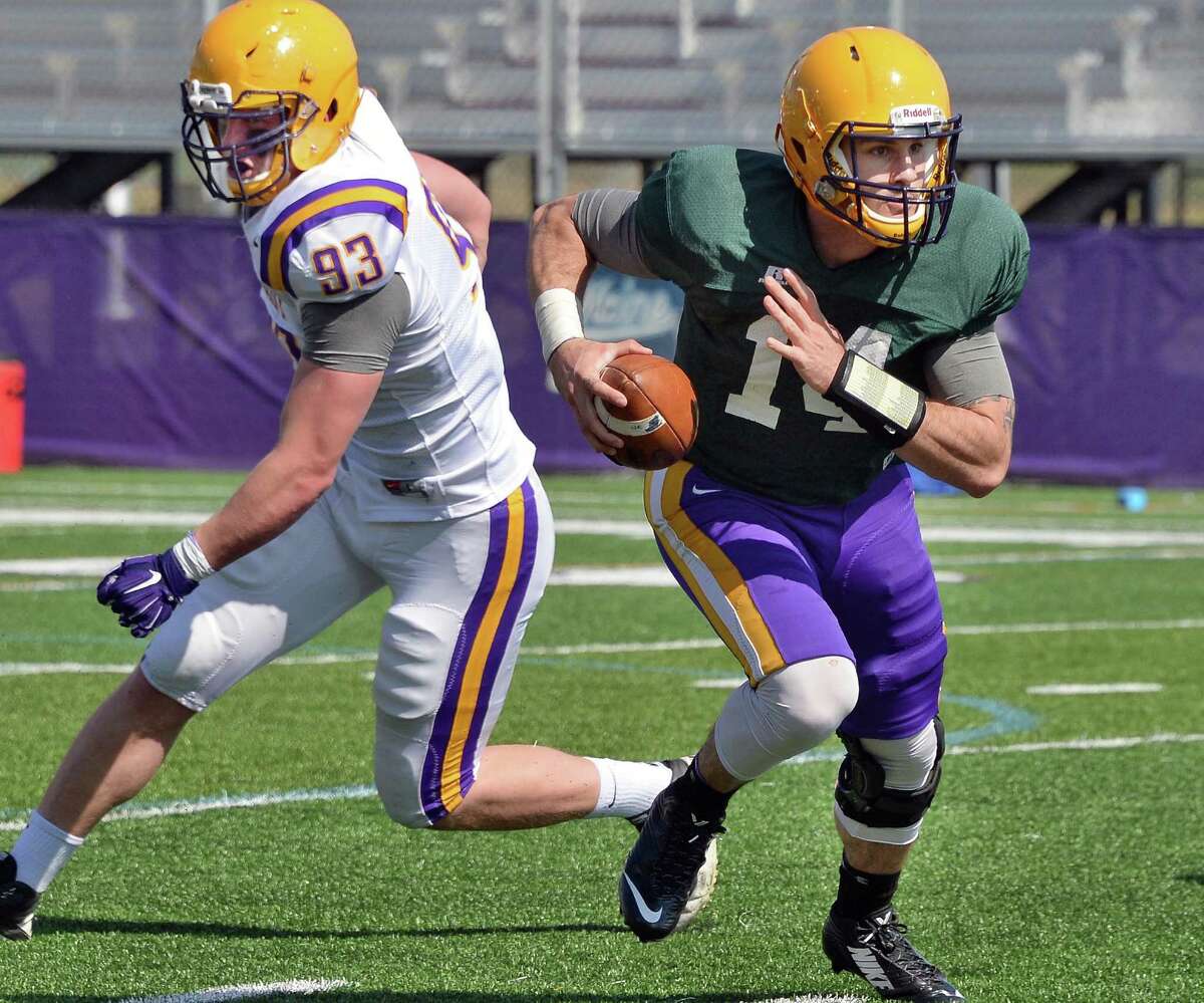 Quarterback #14 DJ Crook, right, scrambles past #93 Jack Forster during UAlbany football's Spring Game Saturday April 18, 2015 in Albany, NY. (John Carl D'Annibale / Times Union)