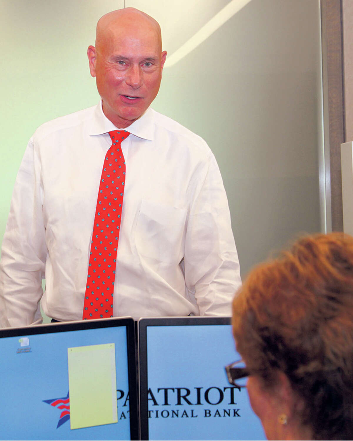 Patriot National Bank CEO Ken Neilson talks with an employee in his Stamford office.