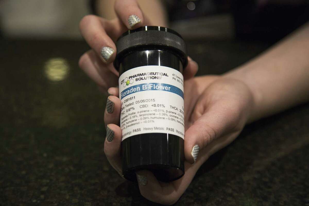 An employee at Laurie Zrenda's dispensary, Thames Valley Alternative Relief in Uncasville, Connecitcut, displays a container for medical marijuana.