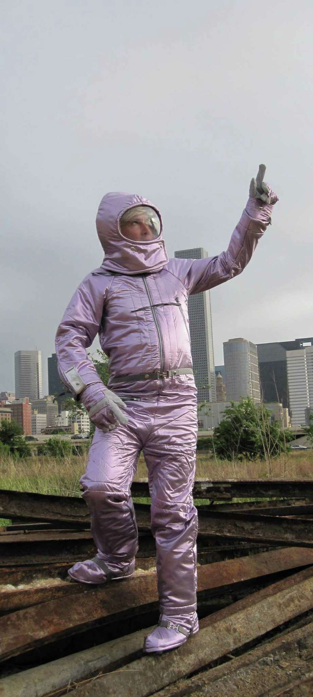 Houston artist Nance wears his award-winning pink spacesuit costume in an image that will appear this fall on signs near the Hilton-Americas Houston and Toyota Center.