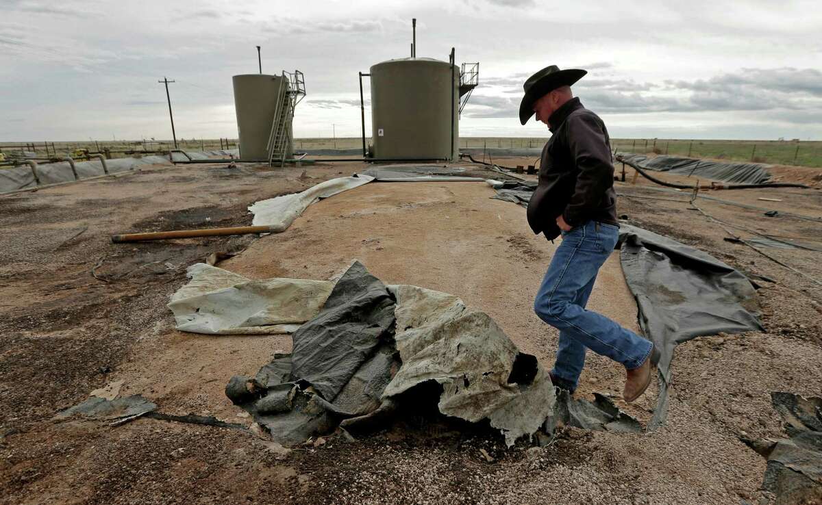 Justin Johnson looks at a torn lining at a tank and pipeline station adjacent to his ranch near Crossroads, N.M. Trucks bring oil field wastewater to the station, where it is pumped through pipelines to a disposal well. The lining is intended to prevent wastewater from seeping into the ground in the event of a leak, but it is in poor condition.
