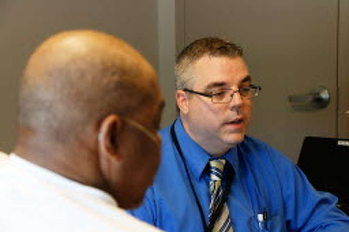 Craig Ritchie, an Ellis Hospital nurse practitioner, visits with patient Fessitcoe Mitchell at his room at the YMCA in Schenectady this summer. Ellis managers identified Mitchell as a patient at high risk for returning to the hospital. Ritchie's regular visits have kept him out of Ellis for nine months. (Olivia Nadel/special to the Times Union)