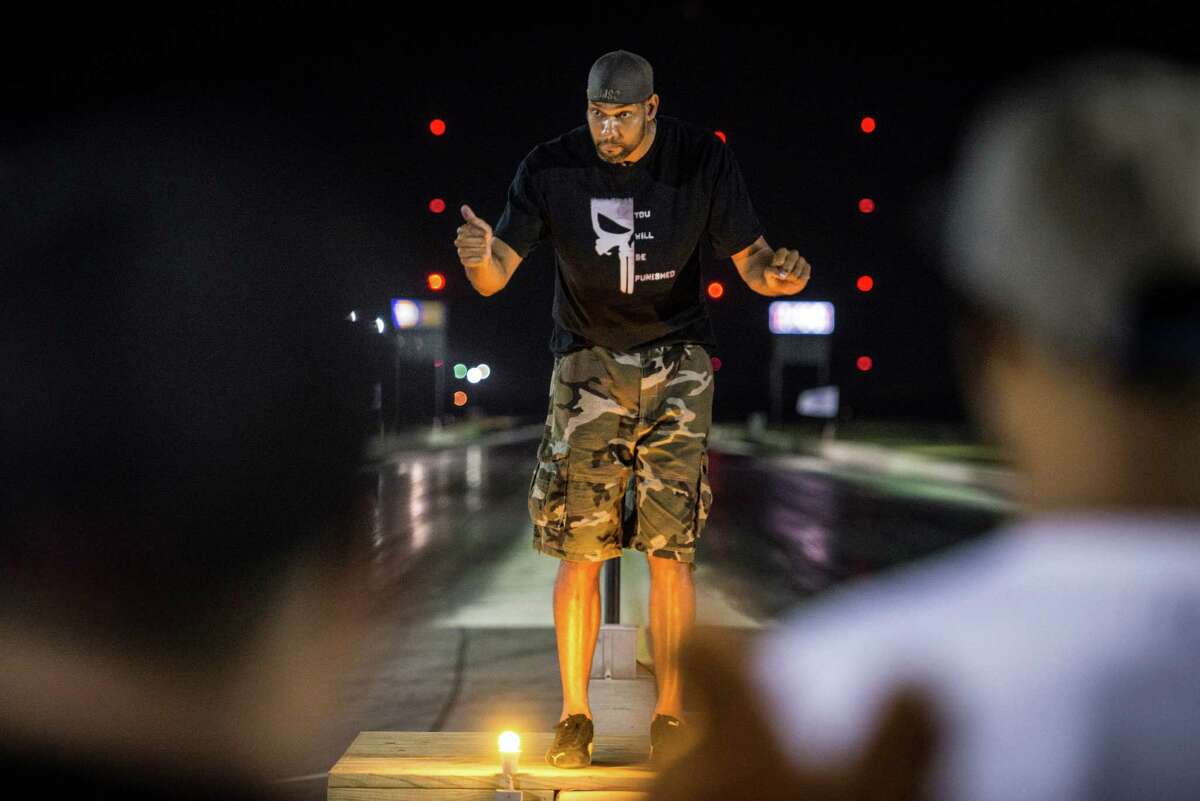 San Antonio Spur Tim Duncan directs racers to the front line during the Black Jack Arm Drop Race at San Antonio Raceway on Saturday, September 5, 2015.