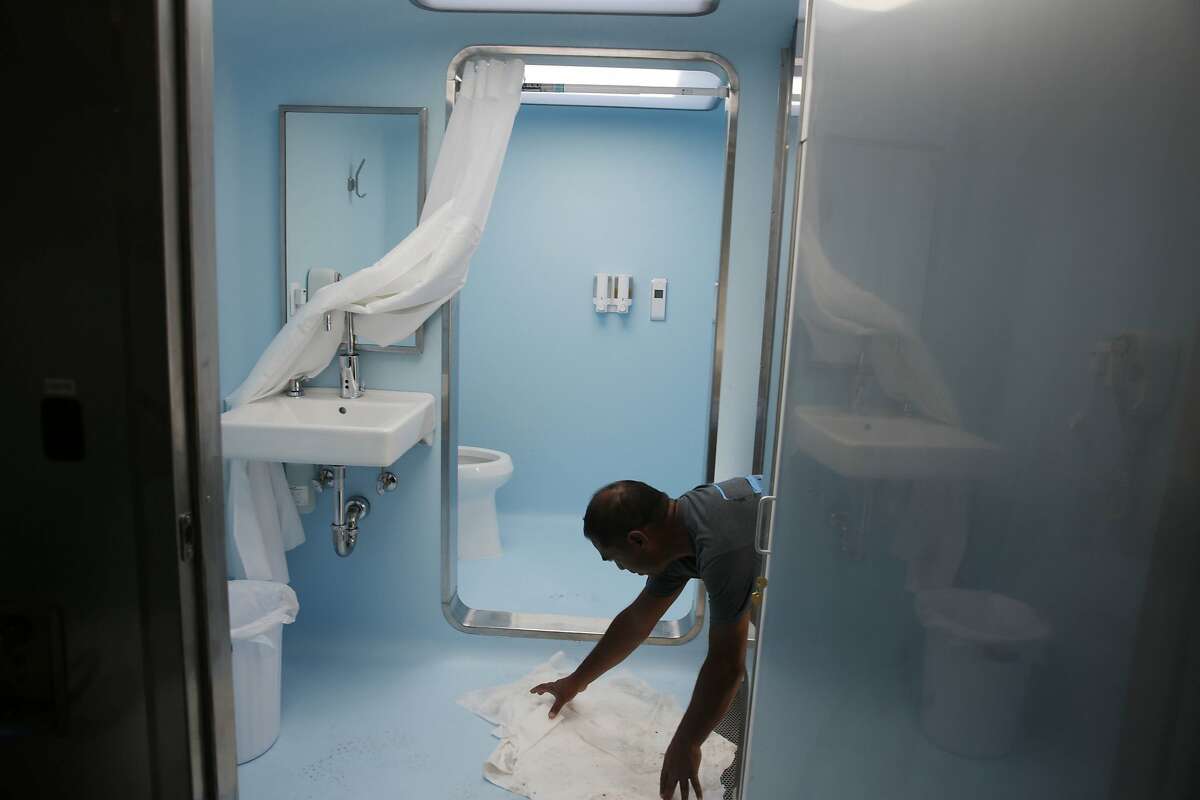 Kumar Mooroteea, volunteer, tidies up towels off the dressing room floor in the new Lava Mae bus on Tuesday, September 8, 2015 in San Francisco, Calif.