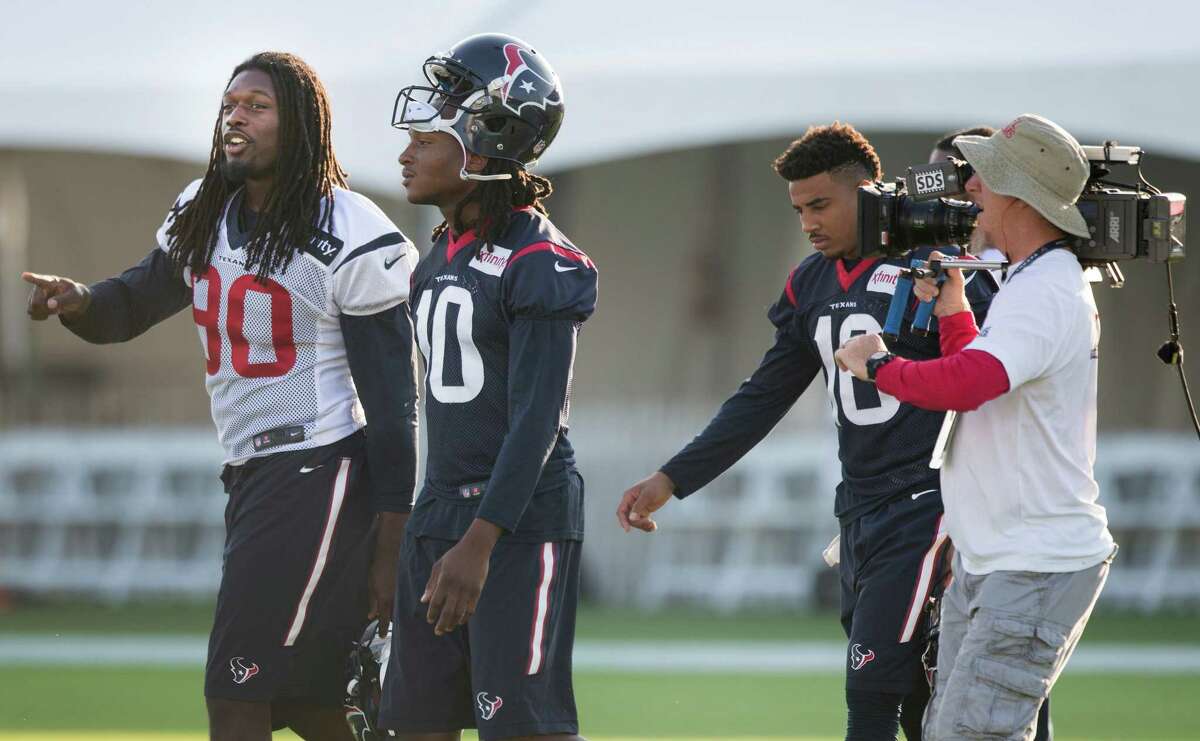 Houston Texans outside linebacker Jadeveon Clowney (90) and wide receiver DeAndre Hopkins (10) walk onto the practice field followed by "Hard Knocks" cameras during Texans training camp at the Methodist Training Center Monday, Aug. 17, 2015, in Houston. Clowney practiced for the first time Monday, since his season-ending micro fracture surgery last season. ( Brett Coomer / Houston Chronicle )